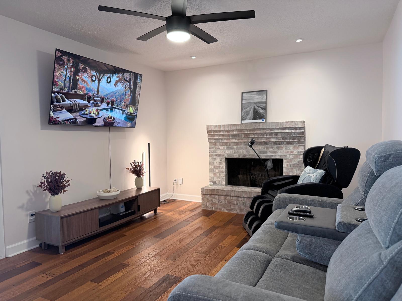 TV lounge with reclining seating and a massage chair